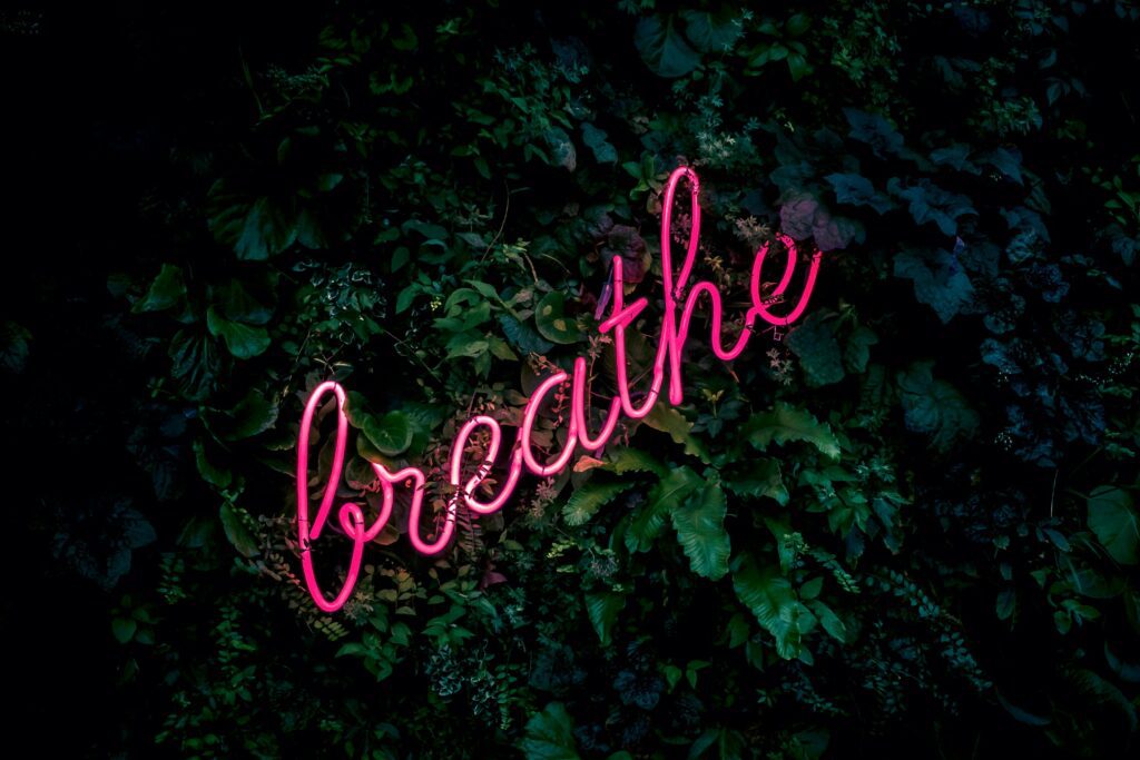 The word “breathe” in neon pink on a green background